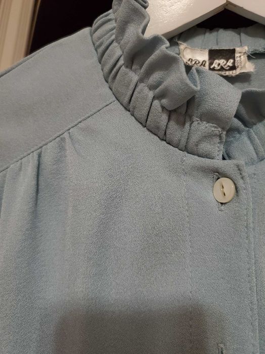 Вінтажна світло-блакитна блузка з рюшами та ґудзиком.