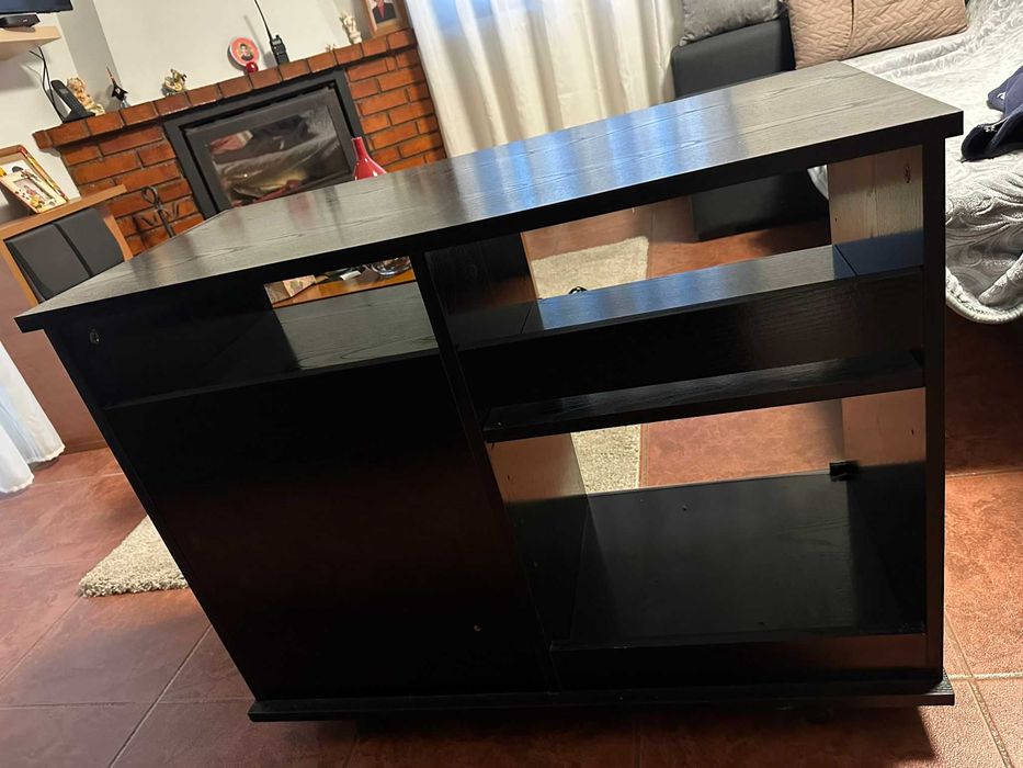 Móvel TV preto com portas de vidro e rodas.