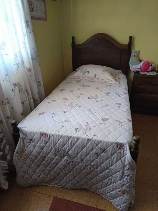Uma cómoda um armário uma mesa de cabeceira e duas camas