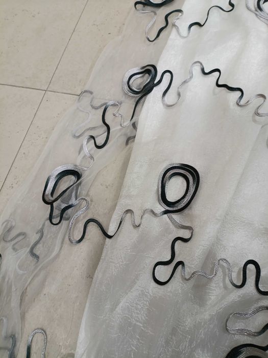 Par de cortinas brancas com apliques pretos e prateados