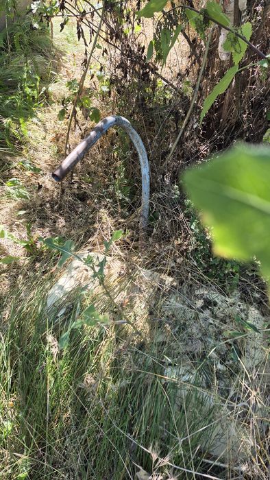 Будинок з джерельною водою на березі річки, асфальтована дорога