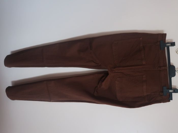 Calças de cor castanha, de cinta subida, com botões de lado