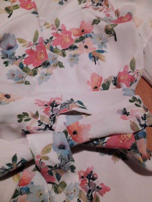 Ошатна сукня скроєна на запах в яскравий квітковий принт.
Mango