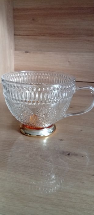 Duża szklana filiżanka ze złotą obwódką na nóżce