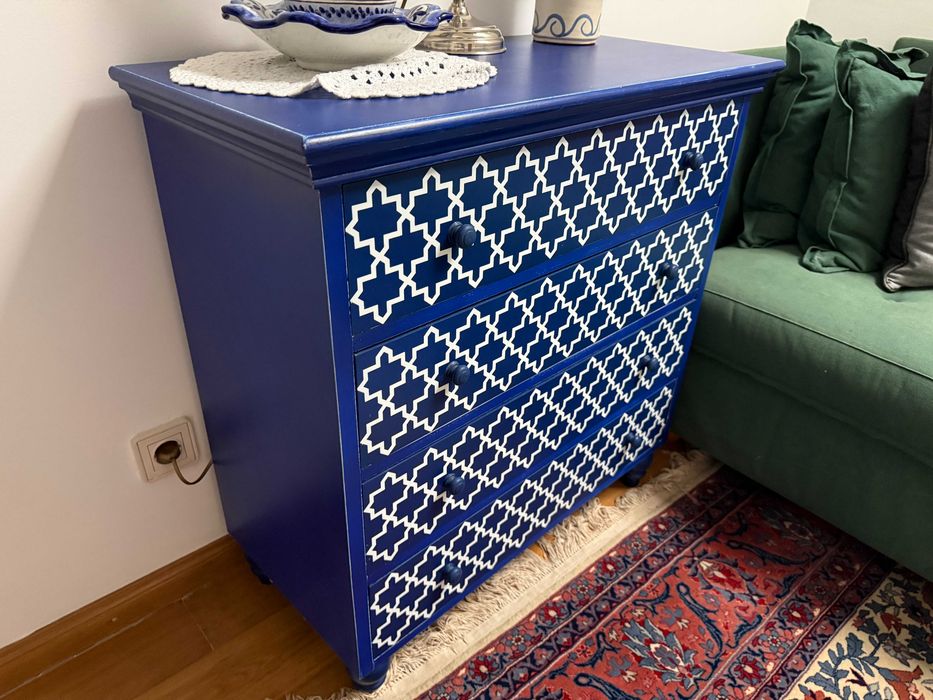 Comoda em madeira no tom azul com detalhes em branco.