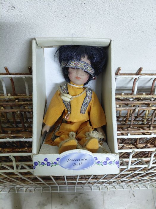 Boneca antiga de porcelana no estado real que se encontra nas fotos