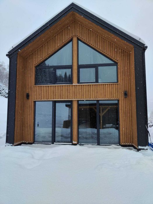 Domek w górach. Nowa nowoczesna stodoła pod lasem.