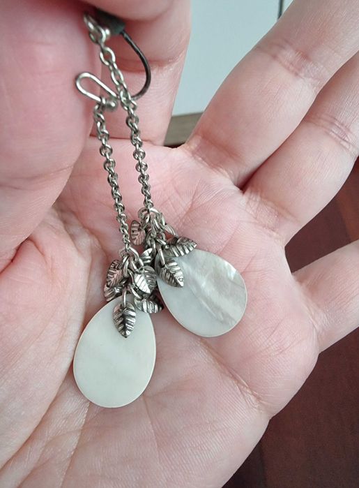 Brincos brancos e prateados com detalhes de folhas