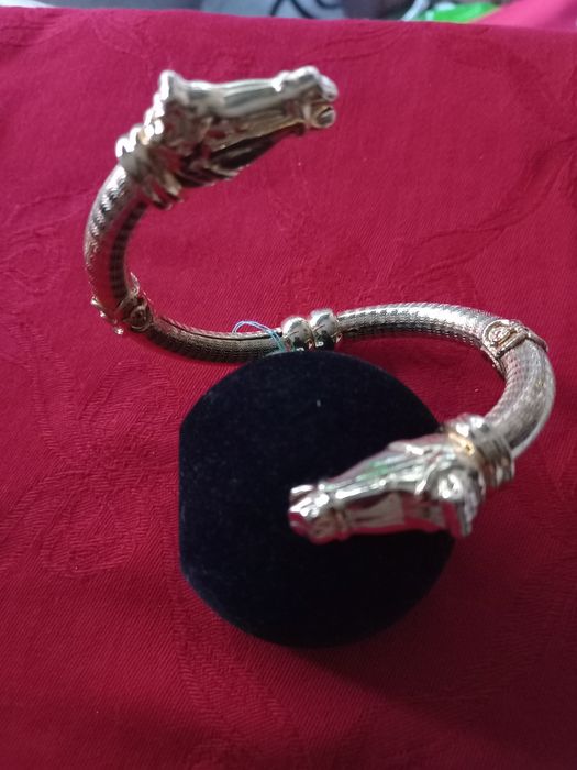 Pulseira dourada com cabeças de cavalo