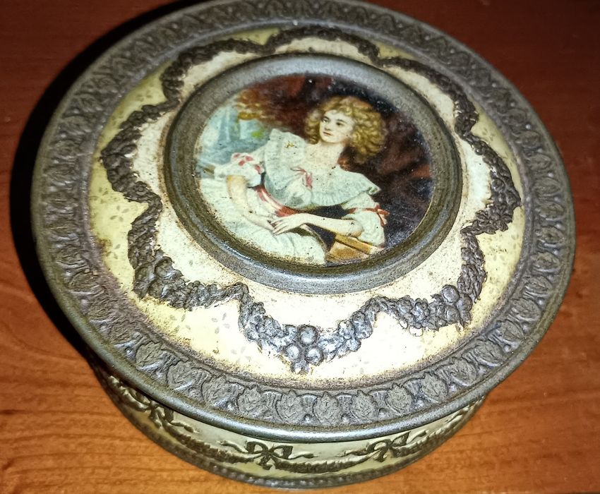 Victorian-style embossed round tin box, vintage red