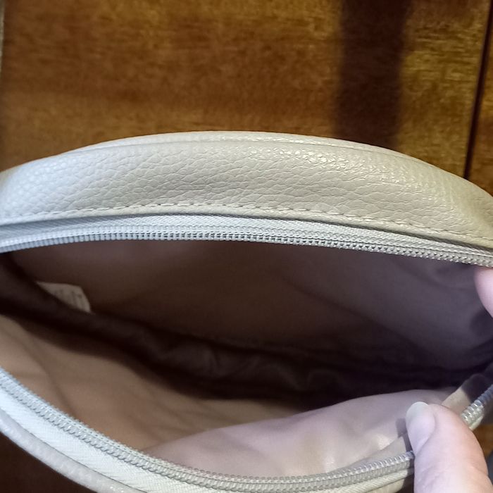 Маленька округла стьобана сумочка від Avon.