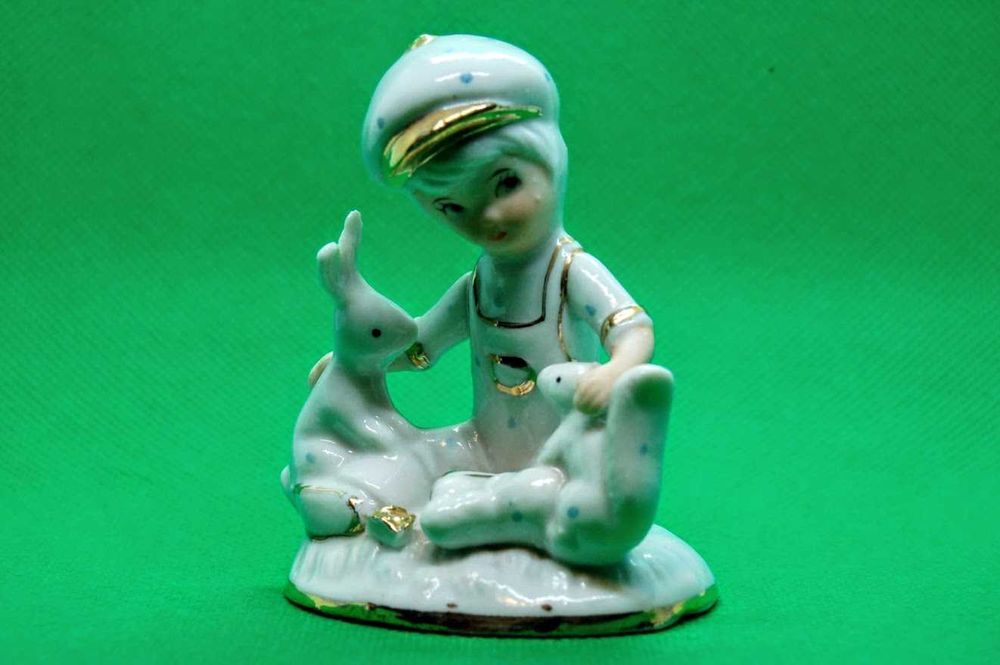 Estatueta antiga de menino em porcelana