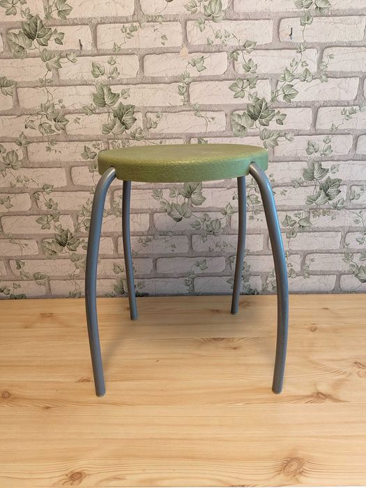 Stylowy taboret prysznicowy – zielone siedzisko, metalowe nóżki.