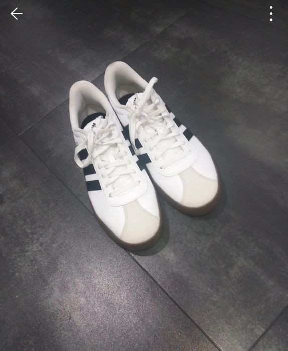 Sapatilhas adidas VL Court 3.0 brancas com detalhes pretos e sola de borracha castanha.