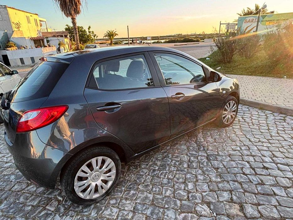 Mazda 2 de 2010, cor cinzenta, com cerca de 140.000 km.