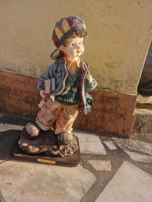 Estatueta de um menino estudante