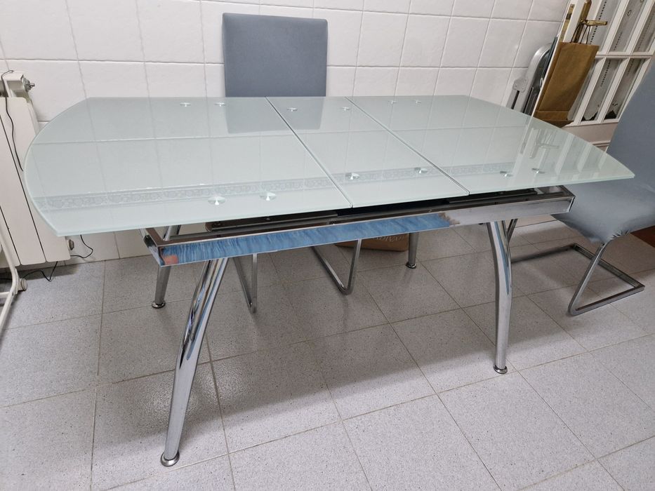 Mesa de cozinha com quatro cadeiras.