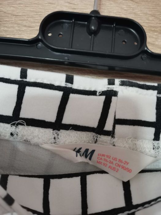 Białe spodnie w czarna kratkę dla dziewczynki firmy H&M.