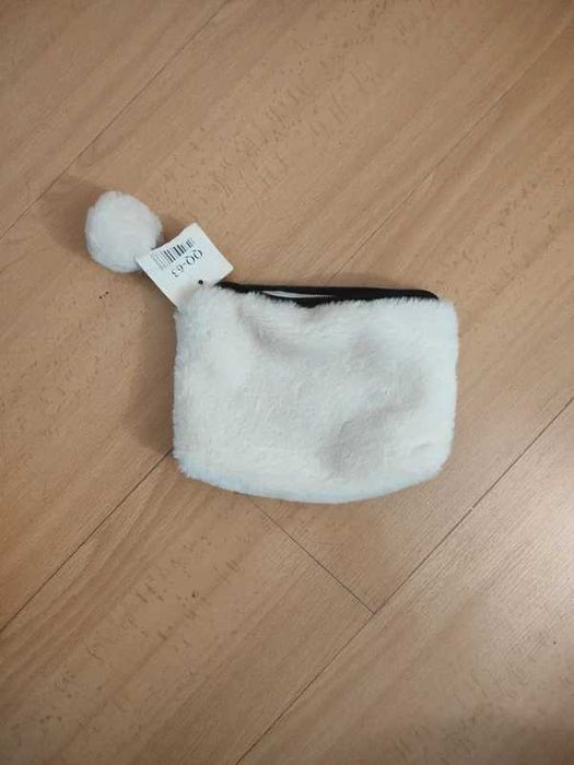 Pequena bolsa de pelúcia branca, frequentemente utilizada como estojo, porta-moedas ou necessaire