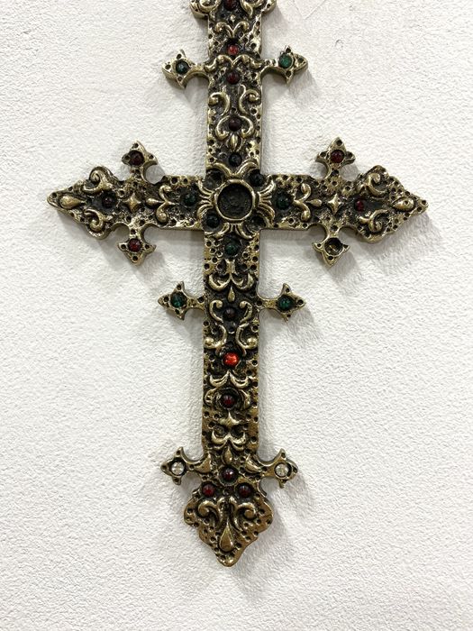 Cruz em metal dourado.