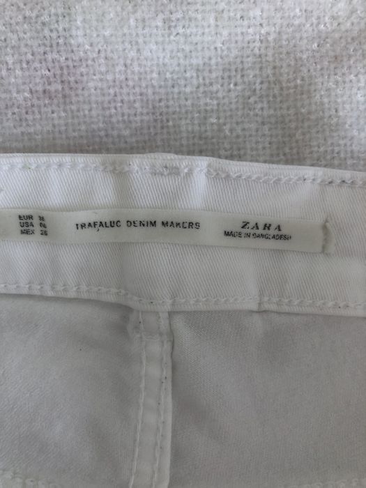 Białe spodnie z przetarciami jeans zara