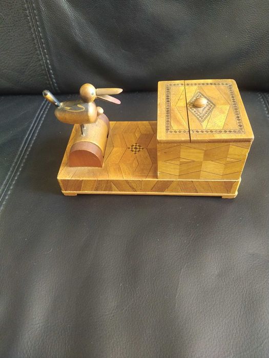 Antiga caixa artesanal, com movimento. Recolhe objetos movendo um peça