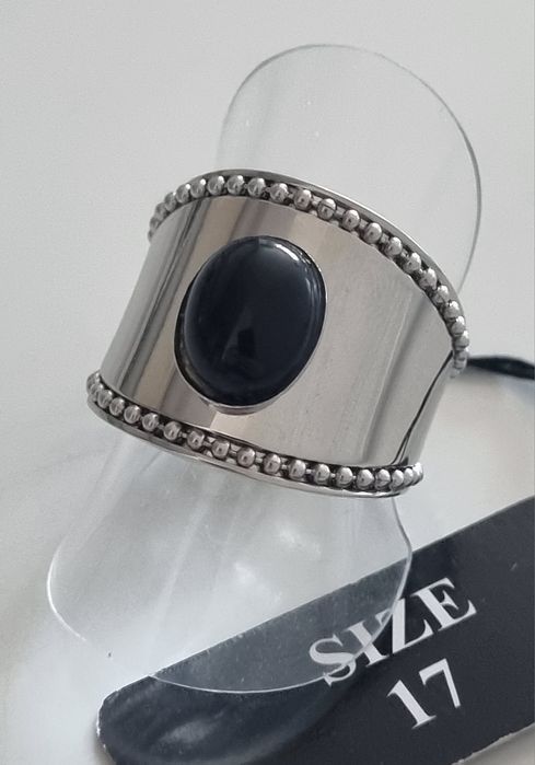 Anel prateado, em aço  com pedra preta oval. Ajustável