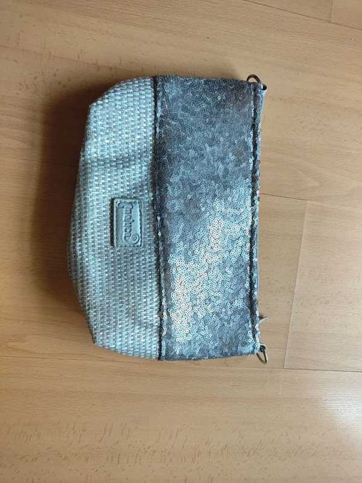 Bolsa de mão prateada com lantejoulas e acabamento em ráfia.