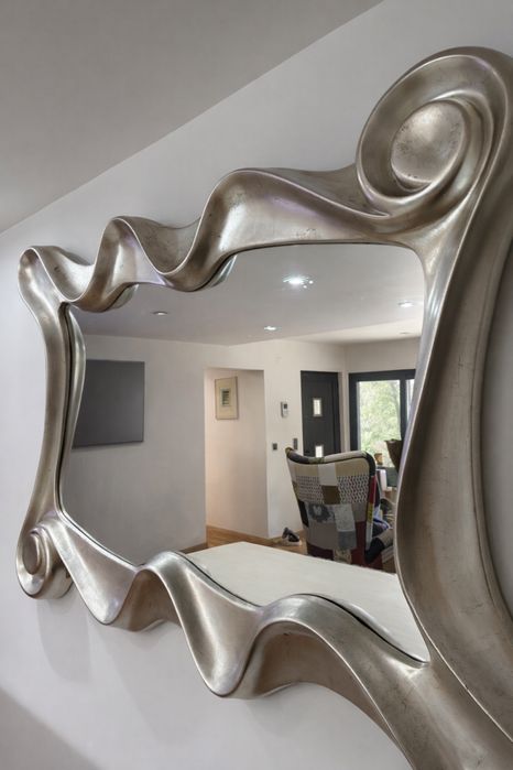 Espelho decorativo grande com moldura ondulada prateada