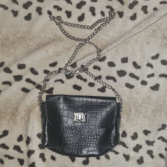 Mała czarna torebka na srebrnym łańcuszku.