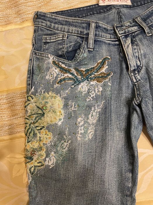 Calças de ganga com bordado em tons de amarelo