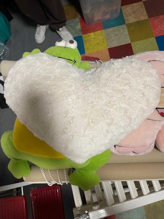 Diversos peluches e almofadas infantis