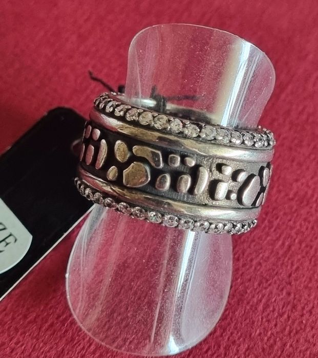 Anel prateado, em aço envelhecido, com fundo preto e zirconias. T18