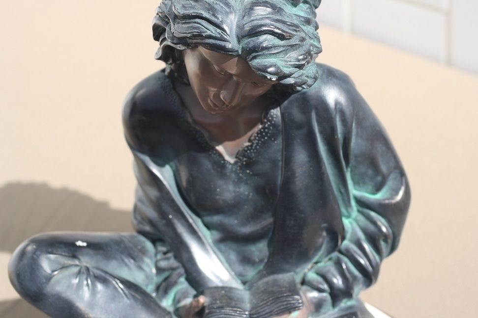 Estatueta de menina a ler