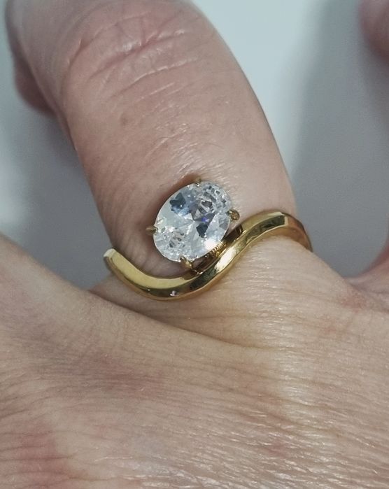 Anel dourado, em aço, muito diferente e com um ponto de luz oval. Ajustável