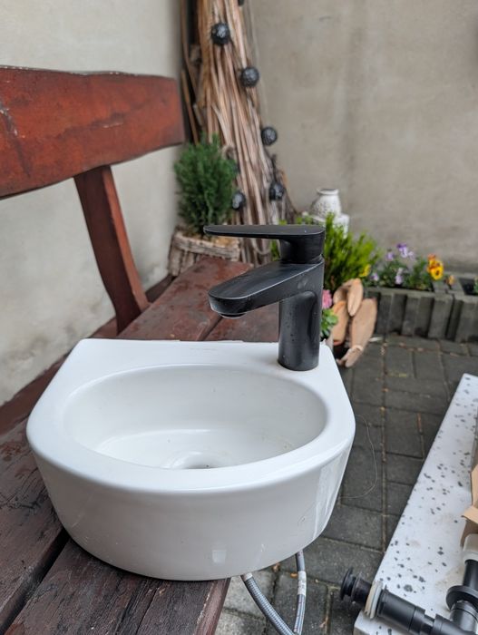 Umywalka z czarną baterią i syfonem