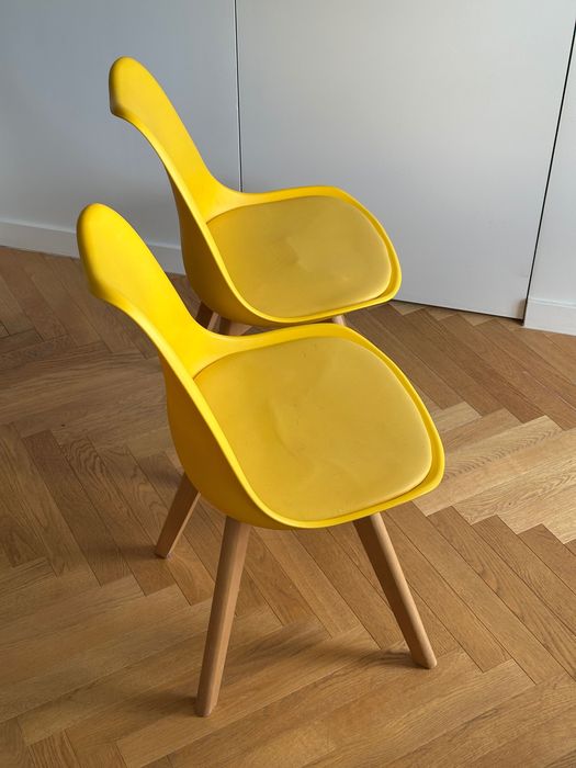 Dwa żółte krzesła na drewnianych nogach skandynawski styl