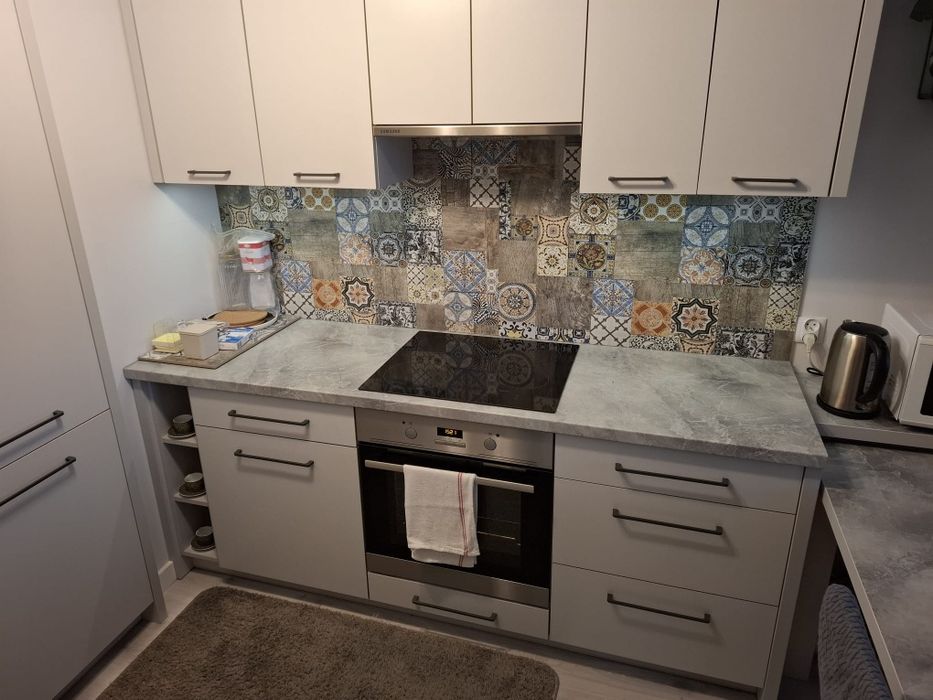 Zabudowa kuchenna ze stołem i sprzętem AGD