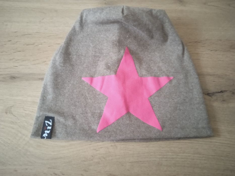 Шапка -біні бежевого кольору з візерунком.