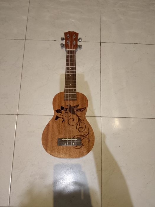 Ukulele com decoração esculpida