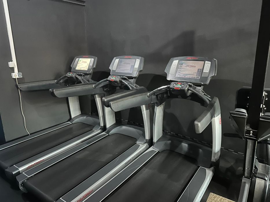 Wyposażenie siłowni life fitness pełne cardio maszyny hantle ławki