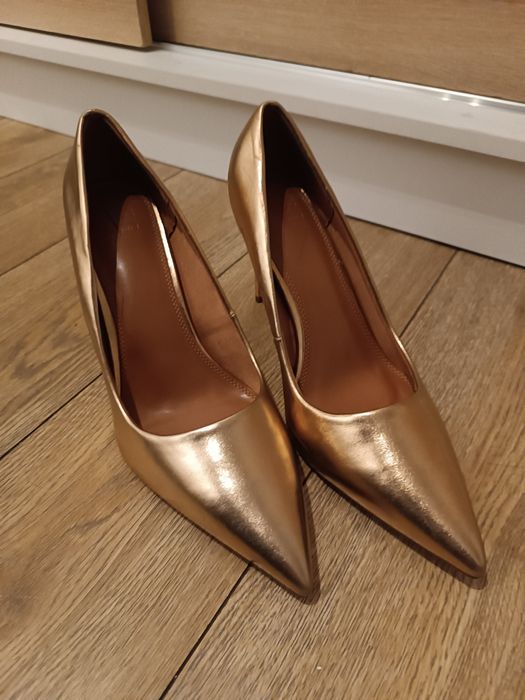 Złote wysokie szpilki