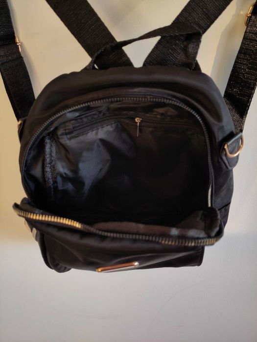 Mochila preta com detalhes dourados