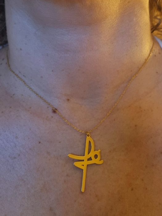 Colar dourado, em aço, a dizer " fé". Tem extensor