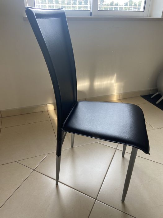 4 cadeiras pretas, mesa de apoio, mesa de jantar, tapetes e cortinados