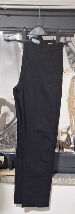 Calças pretas um pouco clássicas e justas ao corpo