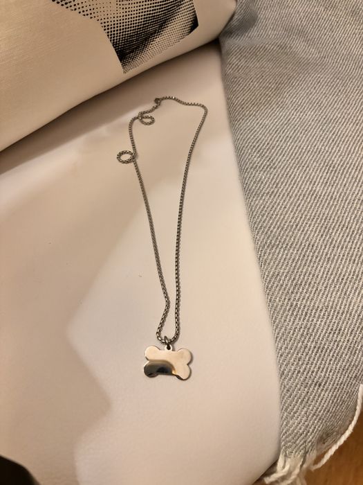 Fio prateado com pendente em forma de osso