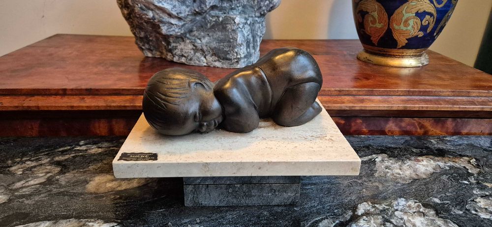 Aukcyjna rzeźba śpiącego dziecka z brązu z ciemną patyną dekor