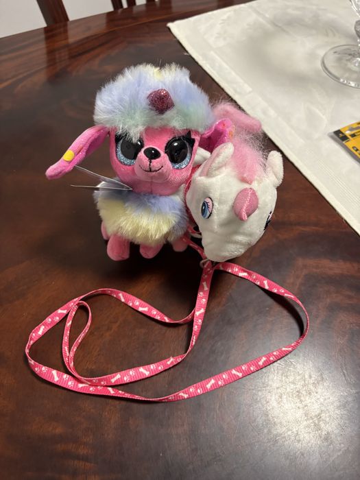 Uma cadela em peluche com trela e toca e outro peluche