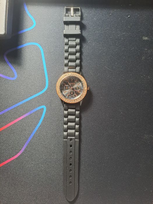 Relógio preto e dourado com pedrinhas